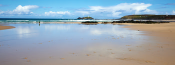 Gofrevy reflections The photograph is a landscape image depicting Godrevy reflections on a sandy beach along the coast of Cornwall, England, United Kingdom. Taken in the morning during the summer, the scene features a wide expanse of sand with patches of water reflecting the blue sky and scattered clouds. The beach stretches towards the sea, where gentle waves meet the shore. In the distance, Godrevy Lighthouse stands prominently on its rocky island, serving as a notable landmark within the landscape. The combination of sunlight, reflections, and coastal features highlights the natural beauty of the area, emphasizing the connection between the beach and the sea at Godrevy in Cornwall.